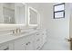 Bathroom featuring white cabinets, dual vanity, and framed mirrors with inset lighting, along with marble flooring at 8503 S 9Th Dr # 17, Phoenix, AZ 85041