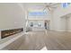 Bright, open living room with a modern fireplace and an open-concept kitchen with white cabinets and tall windows at 8503 S 9Th Dr # 17, Phoenix, AZ 85041