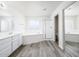 Bright bathroom featuring a soaking tub, glass-enclosed shower, double vanity, and wood-look flooring at 8723 E Kiowa Ave, Mesa, AZ 85209