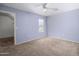 A carpeted bedroom with a ceiling fan and window, painted a pleasant and soft lavender at 8723 E Kiowa Ave, Mesa, AZ 85209