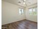 An empty bedroom with wood floors, a ceiling fan, and multiple windows for ample natural light at 8723 E Kiowa Ave, Mesa, AZ 85209