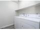 An interior laundry room with a washer and dryer hookups, plus a shelf for storage at 8723 E Kiowa Ave, Mesa, AZ 85209