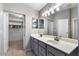 Bathroom featuring double sinks with a large mirror and an open closet with tile floor at 9632 E Olla Ave, Mesa, AZ 85212