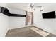 Bright bedroom with carpet, a ceiling fan, shelving, and a television at 9632 E Olla Ave, Mesa, AZ 85212