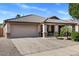 Suburban home featuring a two-car garage, desert landscaping, and a covered front porch offering a welcoming facade at 9632 E Olla Ave, Mesa, AZ 85212