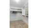 A walk-in closet with tile floors and white shelving and rods for ample storage at 9632 E Olla Ave, Mesa, AZ 85212