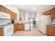 Traditional kitchen features wooden cabinets, white appliances, tile floors, and view to the living room at 10377 W Yukon Dr, Peoria, AZ 85382