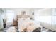 Large main bedroom with white walls, white comforter, ensuite bathroom, and laminate floors at 10377 W Yukon Dr, Peoria, AZ 85382