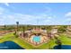 Aerial view of the community pool and clubhouse surrounded by palm trees and a serene pond at 10377 W Yukon Dr, Peoria, AZ 85382
