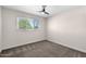 An empty bedroom with plush carpeting, ceiling fan, and bright window at 105 E Hermosa Dr, Tempe, AZ 85282