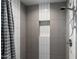 Modern shower with stylish gray and white tiles and convenient recessed shelf at 105 E Hermosa Dr, Tempe, AZ 85282