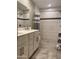 Bright bathroom featuring a double sink vanity, modern white tiling, and a spacious glass door shower at 1055 N 86Th Pl, Scottsdale, AZ 85257
