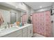 Bright bathroom featuring double sinks and a charming pink floral shower curtain at 1055 N 86Th Pl, Scottsdale, AZ 85257
