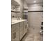 Modern bathroom featuring white cabinets, tiled walls with stylish accent strip, and a sleek shower at 1055 N 86Th Pl, Scottsdale, AZ 85257