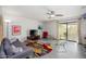 Bright living room with a ceiling fan, unique modern furniture, and sliding doors to the outdoor patio at 1124 E Rose Ln # 17, Phoenix, AZ 85014