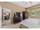 An organized bedroom with an attached living room features a ceiling fan and large window at 12417 W Apache St, Avondale, AZ 85323