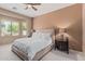 A well-lit bedroom features a large window, ceiling fan, and soft neutral tones at 12417 W Apache St, Avondale, AZ 85323