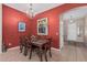 Inviting dining room with red walls, chandelier lighting, and a rustic wood table for Gathering gatherings at 12417 W Apache St, Avondale, AZ 85323