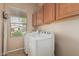 Well-lit laundry room with a washer and dryer and a view to the exterior at 12417 W Apache St, Avondale, AZ 85323
