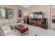 Comfortable living room with a large television, white couch, and light carpet at 12417 W Apache St, Avondale, AZ 85323