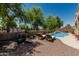 Backyard featuring a blue swimming pool, lounge chairs and desert landscaping at 12417 W Apache St, Avondale, AZ 85323