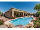 Backyard featuring a blue swimming pool with waterfall and desert landscaping at 12417 W Apache St, Avondale, AZ 85323