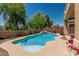 Backyard featuring a blue swimming pool, lush landscaping and an outdoor dining area at 12417 W Apache St, Avondale, AZ 85323