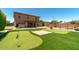 Expansive backyard featuring a pool, putting green, and outdoor seating under a covered patio at 1250 E Canyon Creek Dr, Gilbert, AZ 85295