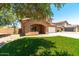 Inviting two-story home featuring an arched porch, lush lawn and mature shade tree at 1250 E Canyon Creek Dr, Gilbert, AZ 85295
