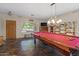 Inviting game room showcasing the pool table and elegant lighting, complemented by shelving and a view of the front yard at 1250 E Canyon Creek Dr, Gilbert, AZ 85295