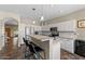 View of kitchen with eat in counter with barstools and white cabinets with stainless steel appliances at 1250 E Canyon Creek Dr, Gilbert, AZ 85295