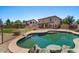 Stunning backyard showcasing a sparkling pool, manicured landscaping, and a charming rock waterfall feature at 1250 E Canyon Creek Dr, Gilbert, AZ 85295