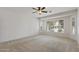 Spacious bedroom features neutral carpet, bright windows with plantation shutters, and a ceiling fan at 13414 W San Pablo Dr, Sun City West, AZ 85375