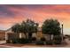 Charming single-story home features desert landscaping and a warm exterior paint color, highlighted by a beautiful sunset sky at 13414 W San Pablo Dr, Sun City West, AZ 85375
