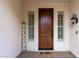 Charming covered entry featuring a solid wood front door flanked by sidelights, accented by a decorative welcome sign at 13414 W San Pablo Dr, Sun City West, AZ 85375