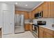 Charming kitchen featuring stainless steel appliances, light countertops, and wooden cabinets at 13414 W San Pablo Dr, Sun City West, AZ 85375