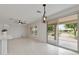 Bright living area with tiled floors, ceiling fan, and sliding glass door to backyard at 13414 W San Pablo Dr, Sun City West, AZ 85375