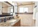 Elegant bathroom with tile walls, granite countertop, framed mirror, and modern shower fixtures at 1413 W 7Th Pl, Tempe, AZ 85281