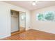 Cozy bedroom with wood-look floors, a mirrored closet, and natural light from the window at 1413 W 7Th Pl, Tempe, AZ 85281