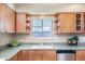 Bright kitchen features wood cabinetry, gray counters, stainless dishwasher, and a view of the sink at 1413 W 7Th Pl, Tempe, AZ 85281