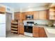 Efficient kitchen featuring wood cabinets, grey counters, and modern stainless-steel appliances at 1413 W 7Th Pl, Tempe, AZ 85281