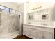 Bright bathroom with a double sink vanity, framed mirror, and tiled shower with glass door at 1492 E Westchester Dr, Chandler, AZ 85249