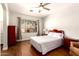 Bedroom with laminate wood flooring, ceiling fan, large window, and red furniture at 1492 E Westchester Dr, Chandler, AZ 85249