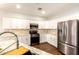 Well-lit kitchen features white cabinets, stainless steel appliances and granite countertops at 1492 E Westchester Dr, Chandler, AZ 85249