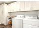 Spacious laundry room with washer, dryer, storage cabinets and folding table at 1492 E Westchester Dr, Chandler, AZ 85249