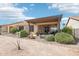 Home's backyard with a covered patio and desert landscaping at 16165 W Vale Dr, Goodyear, AZ 85395