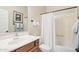 This bathroom features a white vanity, a neutral shower with white shower curtain, and matching towel racks at 16165 W Vale Dr, Goodyear, AZ 85395