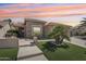Charming home featuring stone accents, manicured lawn, and desert landscaping at 16165 W Vale Dr, Goodyear, AZ 85395