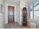 Welcoming foyer features tile flooring, a wooden front door, and abundant natural light at 16165 W Vale Dr, Goodyear, AZ 85395