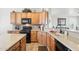 The kitchen features wooden cabinets, granite countertops, a black gas range, and a double basin sink with modern faucet at 16165 W Vale Dr, Goodyear, AZ 85395